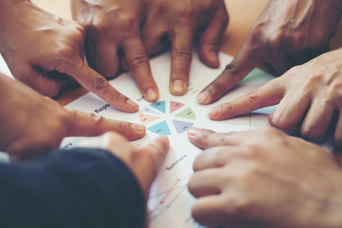 Mains jointes au centre, symbolisant la force du réseau et la collaboration favorisées par le service Échange et Développement.